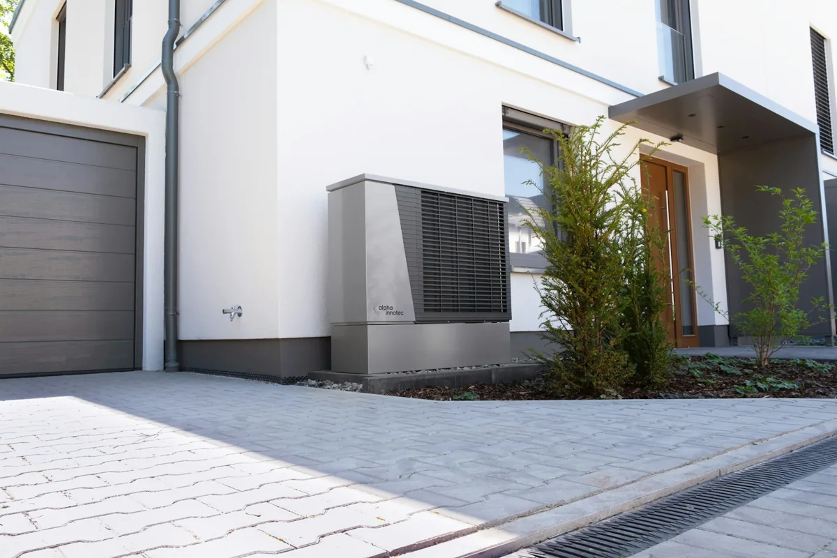 Pompe à chaleur extérieure installée près d’une maison, photographie d’illustration